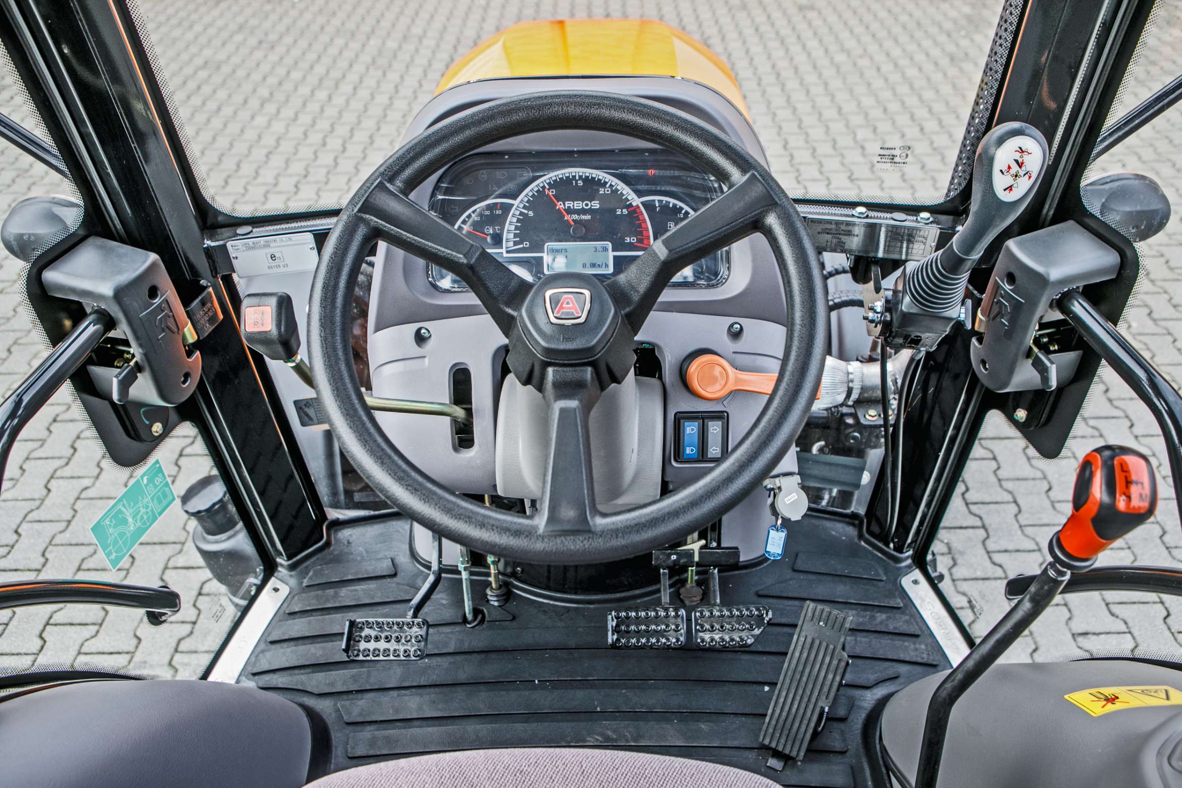 Wnętrze ciągnika Arbos 3055 z deską rozdzielczą i joystickiem do sterowania przednim TUZ