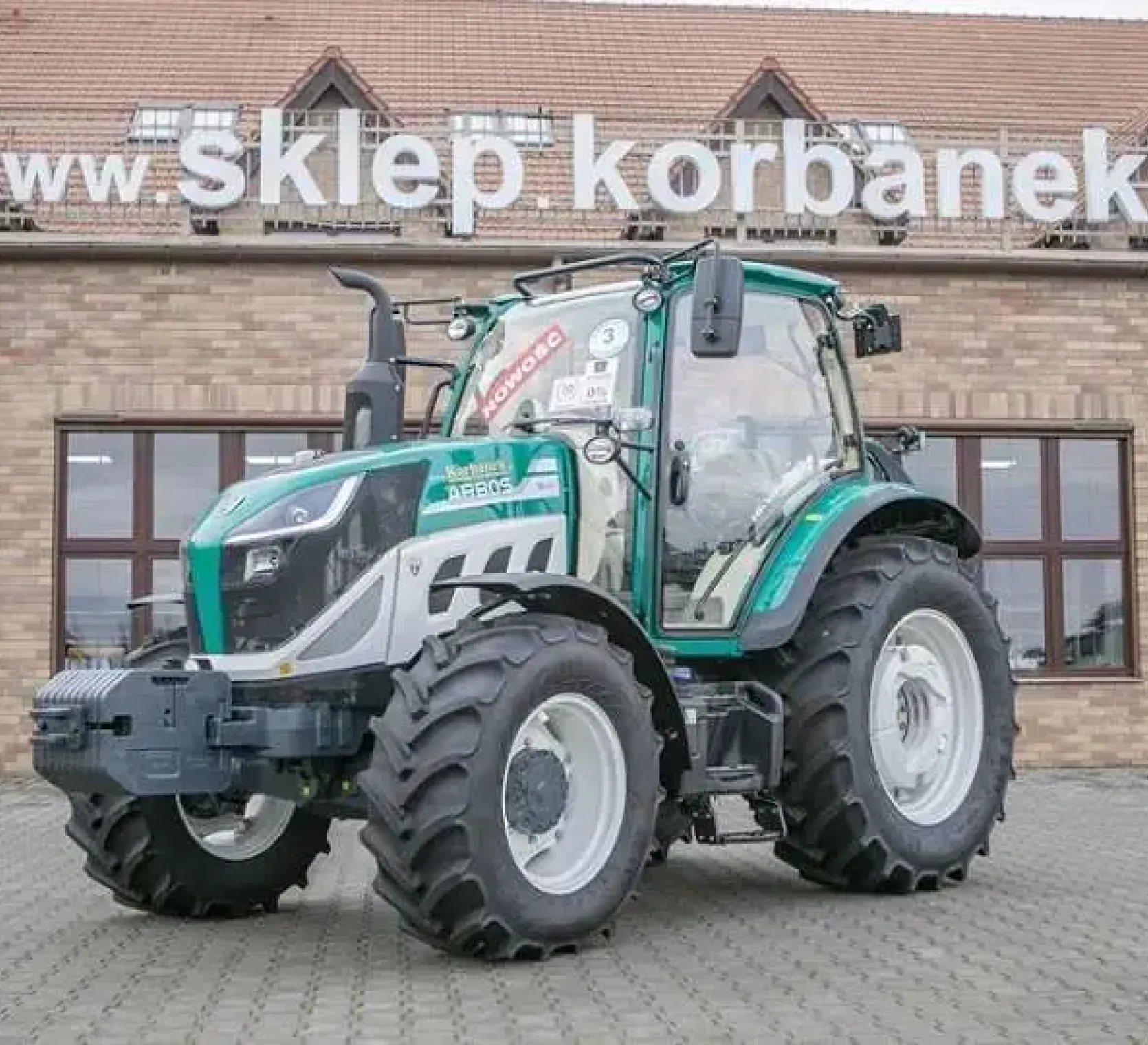 Ciągnik arbos 5115 advanced a w tle jest sklep korbanek