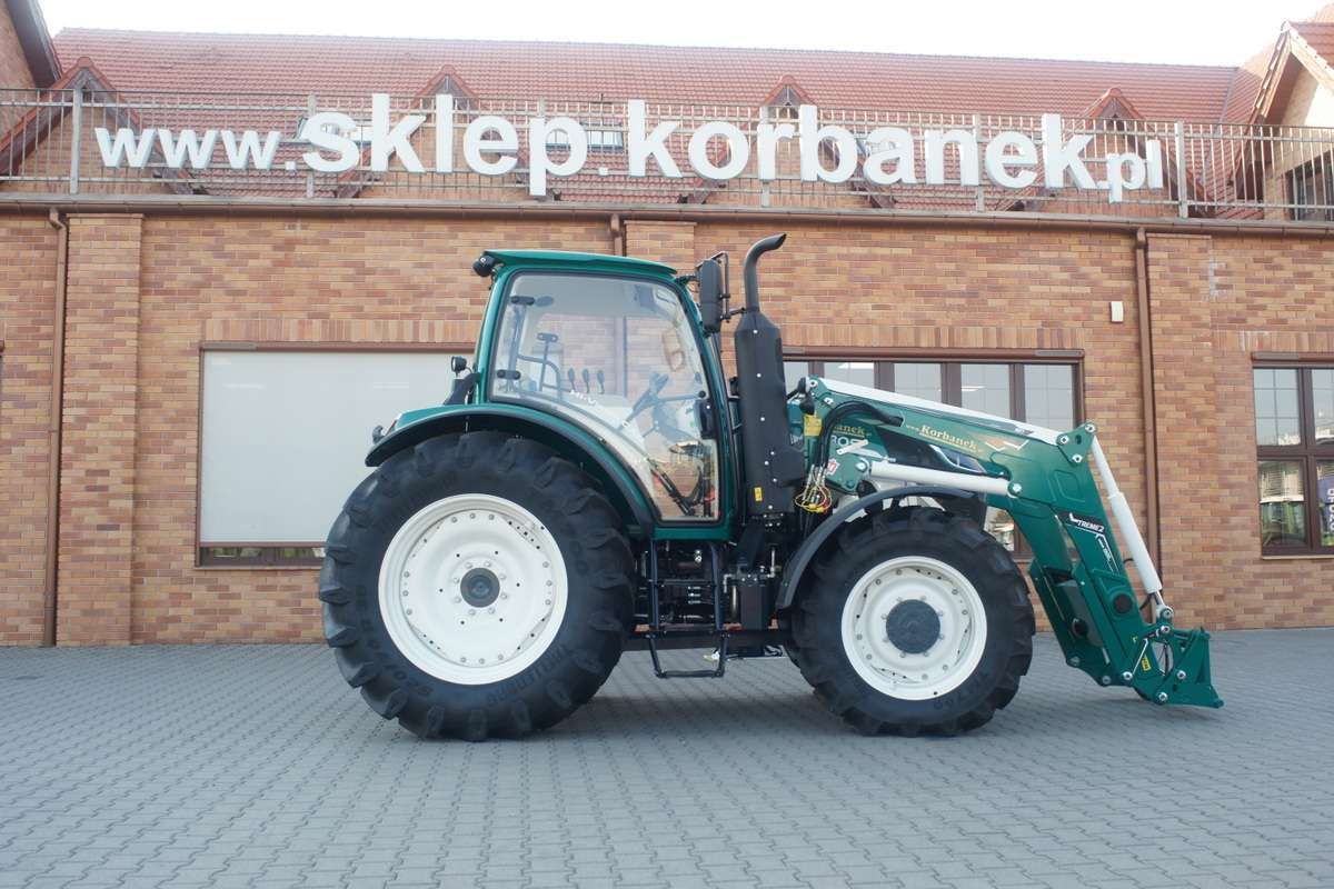 zielono bialy traktor przed magazynem czesci do maszyn rolniczych