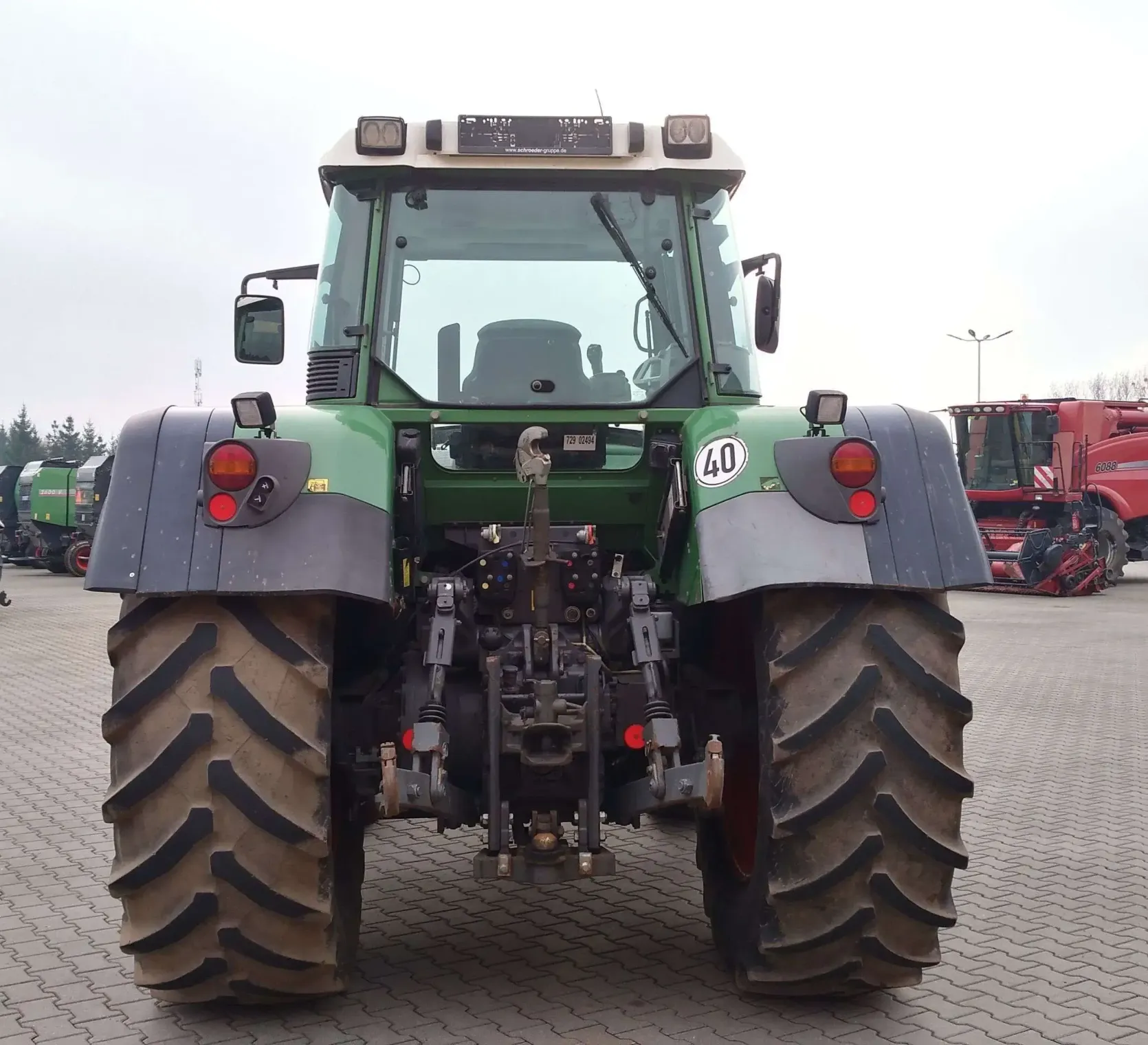 Ciągnik Fendt 818 Vario TMS na tle placu maszyn firmy  Korbanek widok z tyłu
