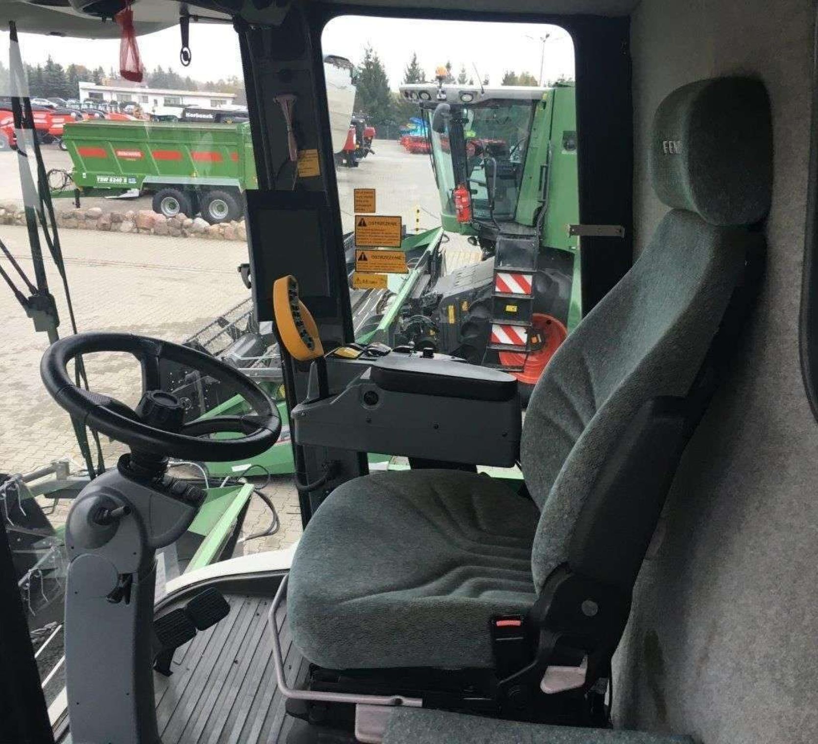 Klimatyzowana kabina kombajnu Fendt 8370 zdjęcie wnętrza z lewej strony w tle plac maszyn korbanek.pl
