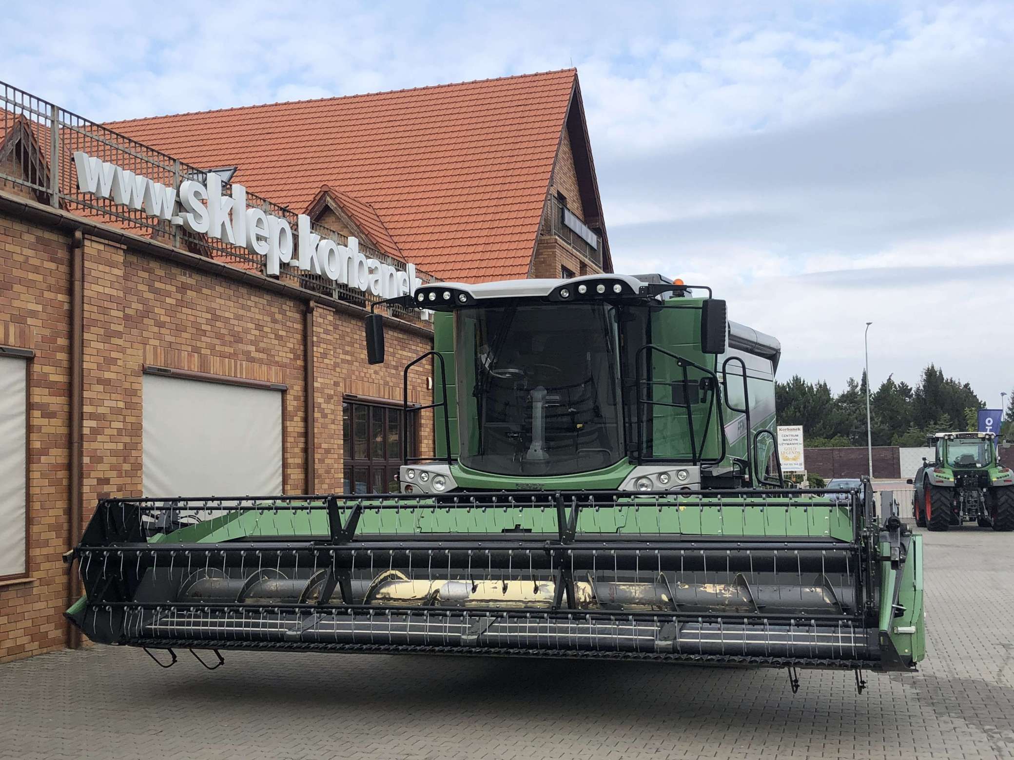 Używany kombajn 6 klawiszowy do zbioru zbóż Fendt 6335 C przed sklepem części zamiennych firmy Korbanek 