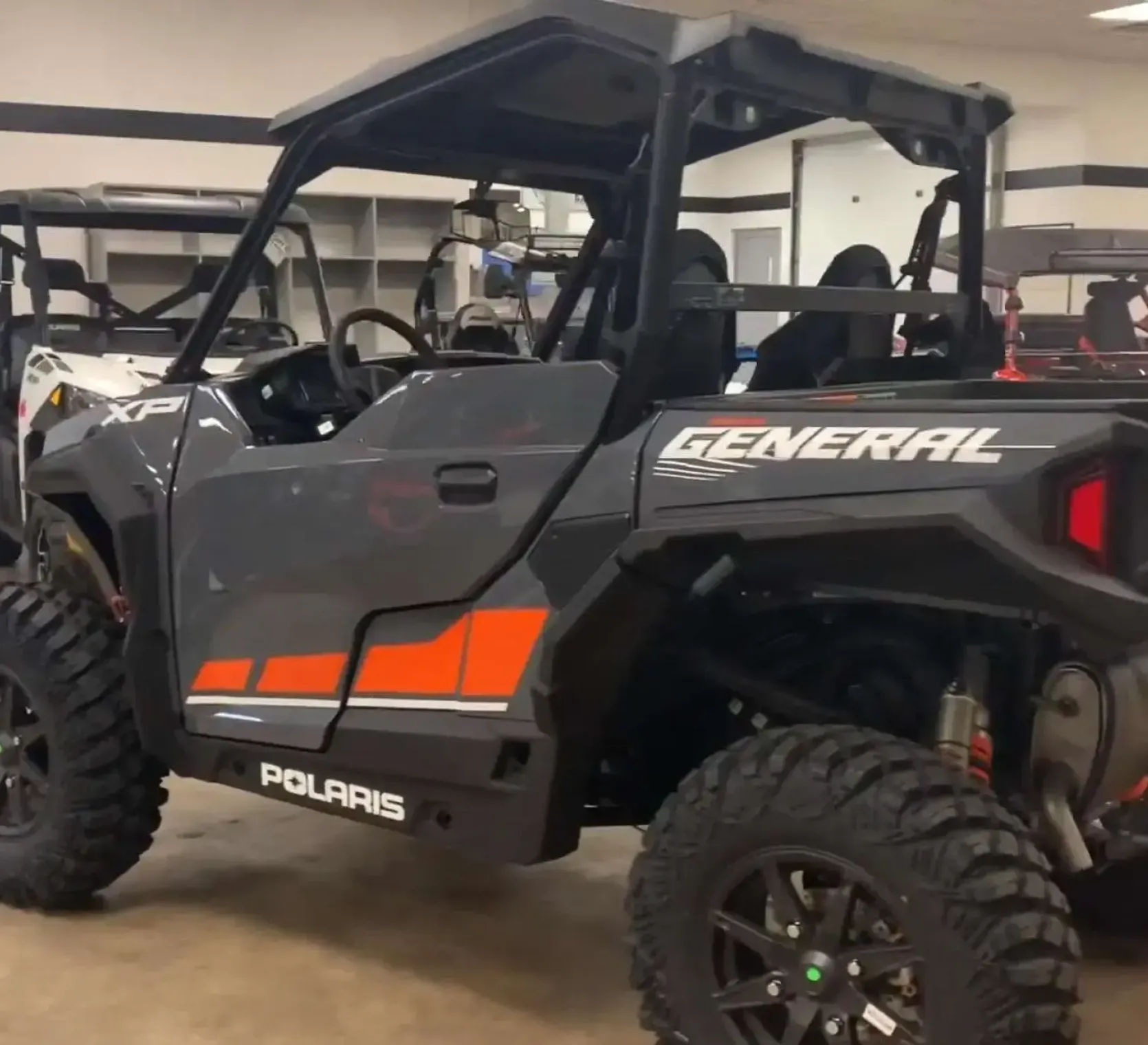 Czarno - pomarańczowy quad Polaris seria  GENERAL XP 1000 atv DELUXE EPS ABS widok na bok pojazdu 
