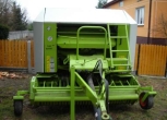 Claas Rolant 255 RC używana prasa widok z przodu w tle budynek 
