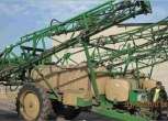 Używany Opryskiwacz Great Plains szerokośćr robocza 24m w tle budynek 