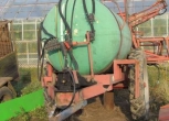 Opryskiwacz używany Rauch 2000 l belka 18 m  na tle szklarni 