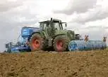 Używany traktor rolniczy Fendt 718 Vario podczas pracy z siewnikiem Lemken oraz wałem uprawowym