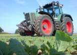 Używany zadbany ciągnik rolniczy Fendt 926 Vario jadący polną drogą 