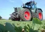 Używany zadbany ciągnik rolniczy Fendt 926 Vario jadący polną drogą 