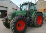 Zielony ciągnik niemieckiego producenta Fendt 714 Vario w zabudowaniach gospodarstwa 