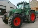 Zielony ciągnik niemieckiego producenta Fendt 714 Vario w zabudowaniach gospodarstwa 