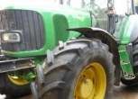 Przód ciągnika John Deere 6920, stojącego na utwardzony podłożu.