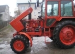 Widok na lewy bok używanego ciągnika rolniczego MTZ 82 KM z uniesioną maską 