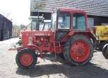 Bok używanego ciagnika rolniczego MTZ 82 w zabudowaniach gospodarstwa 