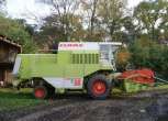 Używany Kombajn zbożowy Claas Dominator 88s widok z prawej strony na tle wysokich drzew