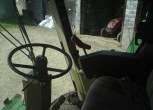 Zdjęcie przedstawiające wnętrze kabiny kombajnu używanego John Deere 2056. 