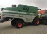 Kombajn używany FENDT 8370 P na utwardzonym placu w tle budynek z czerwonym dachem widok z prawego boku