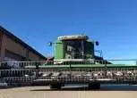 Zielony kombjan Fendt 8370 P z uniesionym hederem do zbioru zbóż  FT 770 PF z kosami bocznymi do zbioru rzepaku