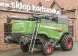 Prawy bok używanego kombajnu Fendt 6275 L  na tle sklepu części zamiennych społki Korbanek 