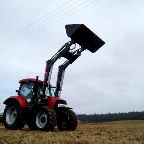 Widok z boku czerwonego traktora rolniczego CASE z podniesionym czarnym ładowaczem Xtreme 3 firmy Hydramet www.korbanek.pl