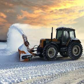 TORNADO 252 pomarańczowy pług wirnikowy firmy samasz podczepiony do pomarańczowego ciągnika rolniczego usuwa śnieg z placu www.korbanek.pl