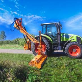 Widok z boku zielonego traktora rolniczego koszącego pobocze drogi kosiarką bijakową KWT 651 firmy SaMASZ www.korbanek.pl