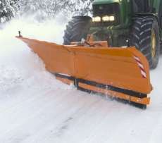 Spychacz do śniegu Alps firmy Samasz pług do odśnieżania zaczepiony na zielonym ciągniku odśnieża drogę 