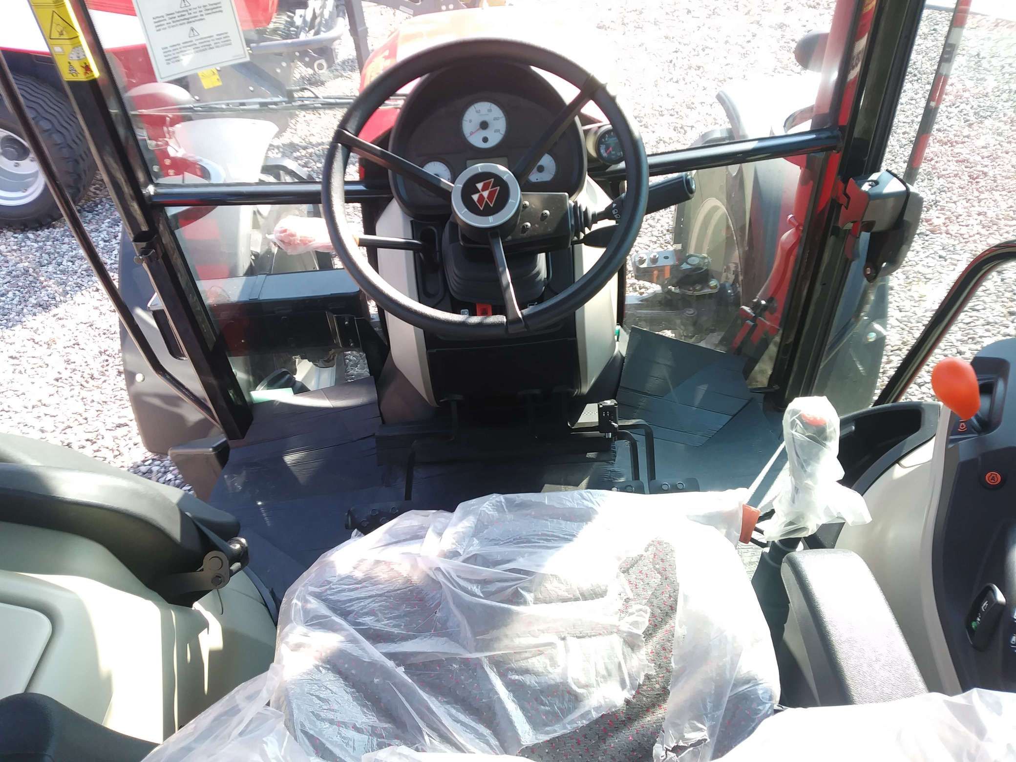 Wnętrze kabiny w ciągniku rolniczym Massey Ferguson 4707 widok na kierownicę