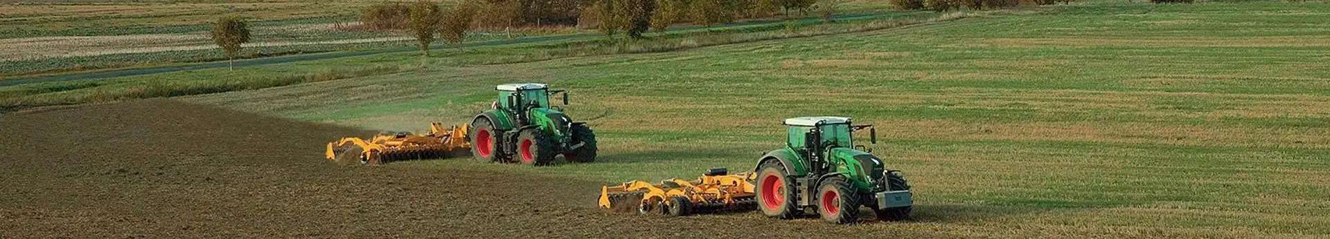 Zdjęcie dwóch agregatów uprawowych AGRISEM pracujących na polu z zielonymi ciągnikami korbanek.pl
