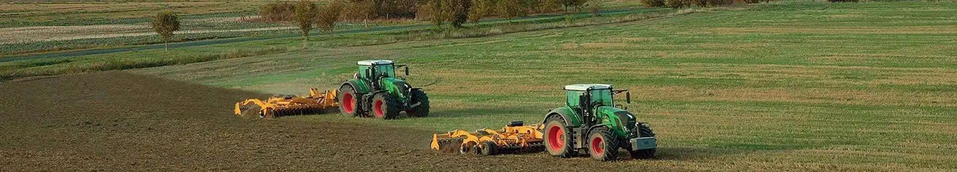 Agrisem maszyny uprawowe agregaty podorywkowe przedsiewne Zdjęcie dwóch agregatów uprawowych AGRISEM pracujących na polu z zielonymi ciągnikami korbanek.pl